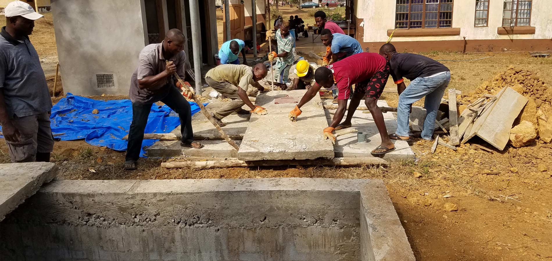 The covering slabs for the cesspit, which serves the admissions building restrooms, are put in place.